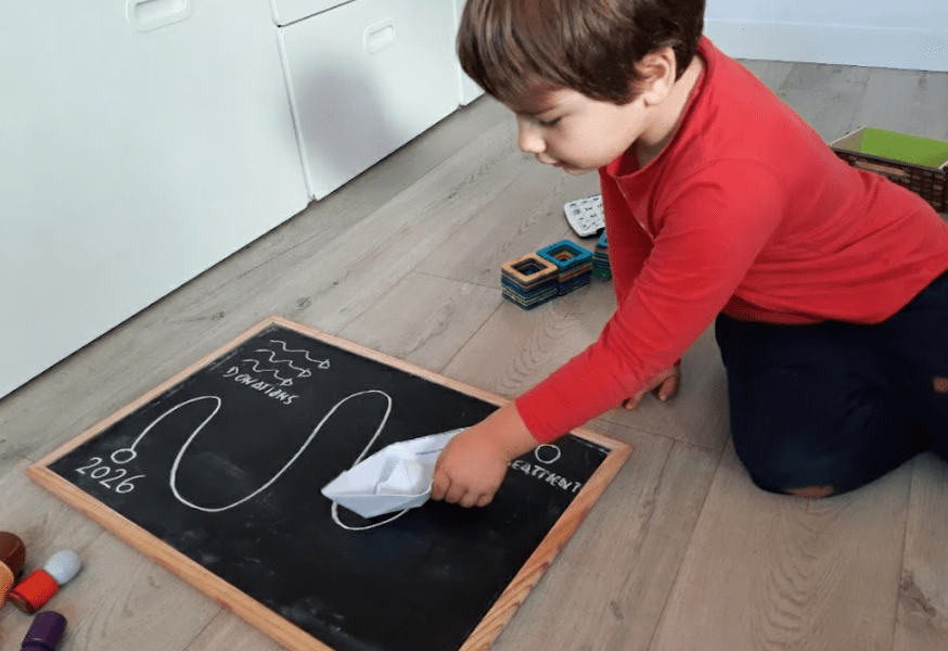 Niño moviendo un barco de papel hacia el futuro